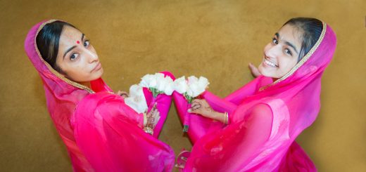 Bridesmaids holding flowers, looking up and smiling at the camera.
